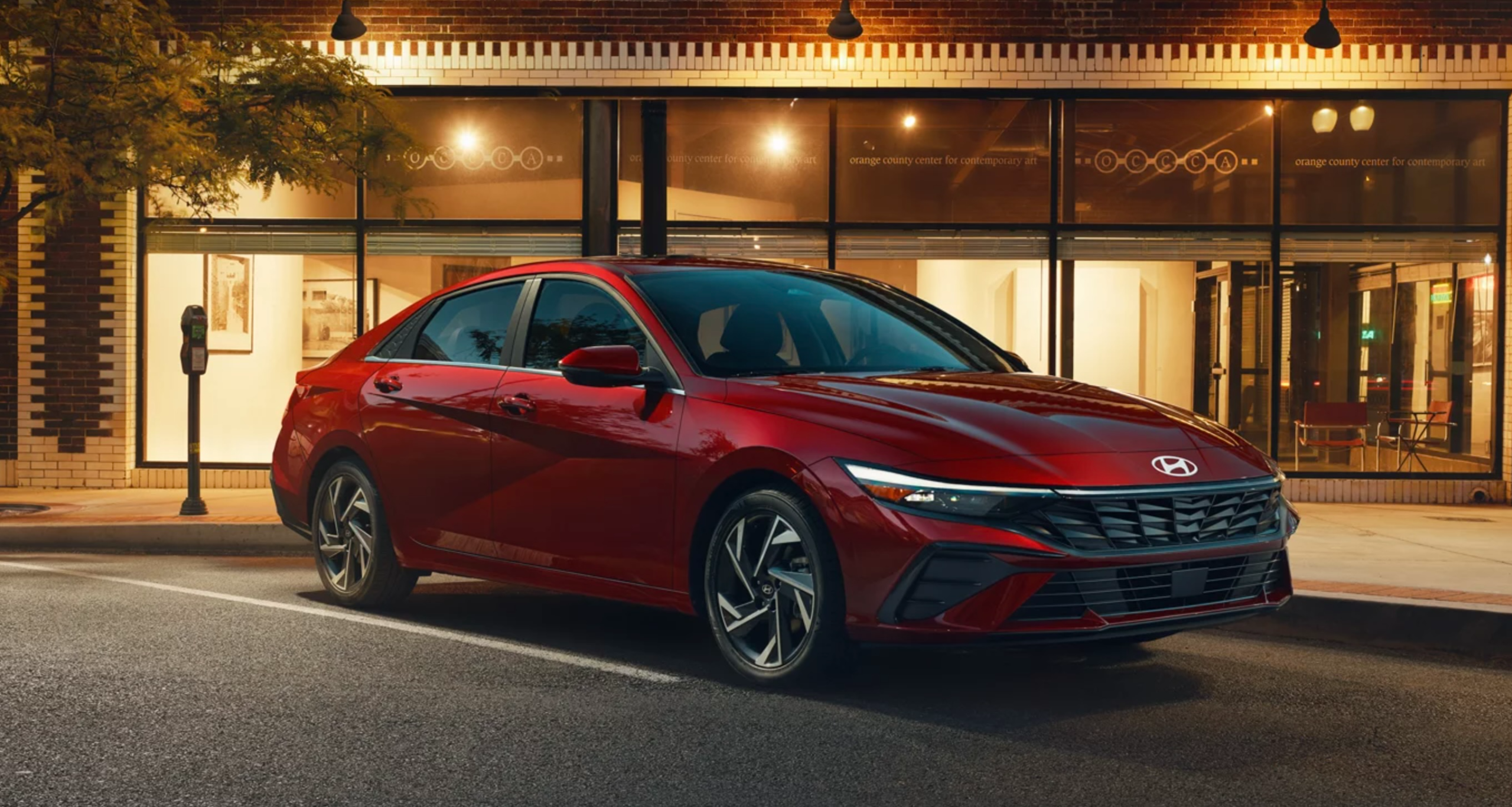 2025 Hyundai Elantra in Red parked in a city outside a restaurant